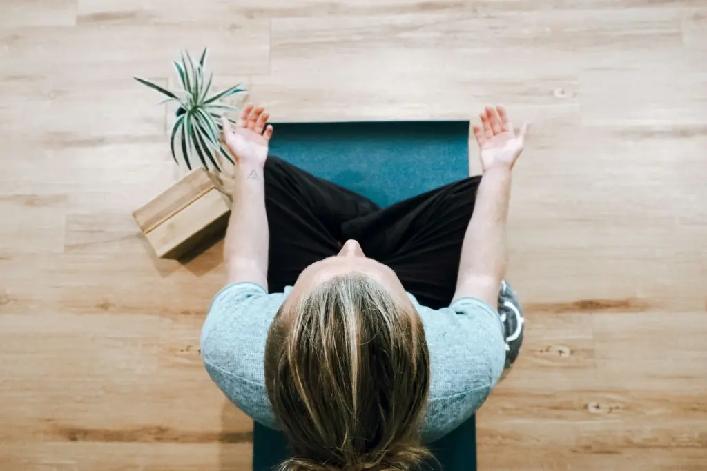 Woman meditating on the floor seen from above