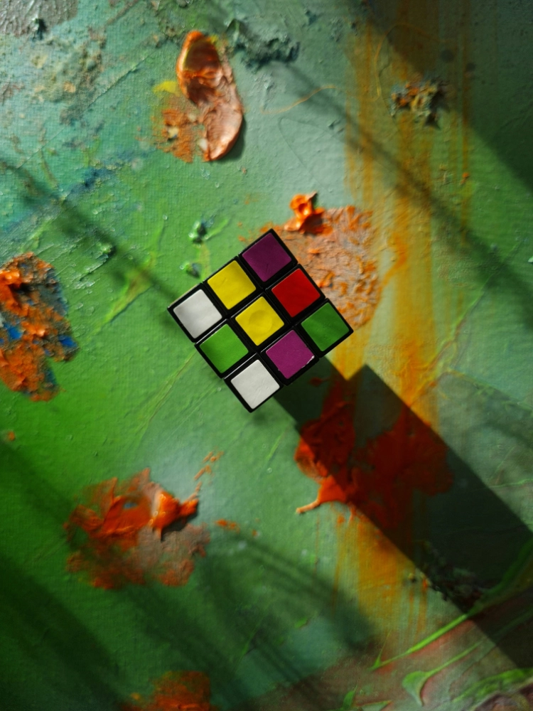 Color palette with a cube and scattered pigments