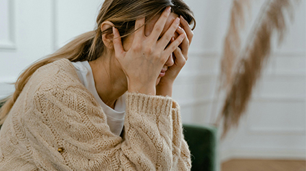 Woman covering her face with her hands in distress
